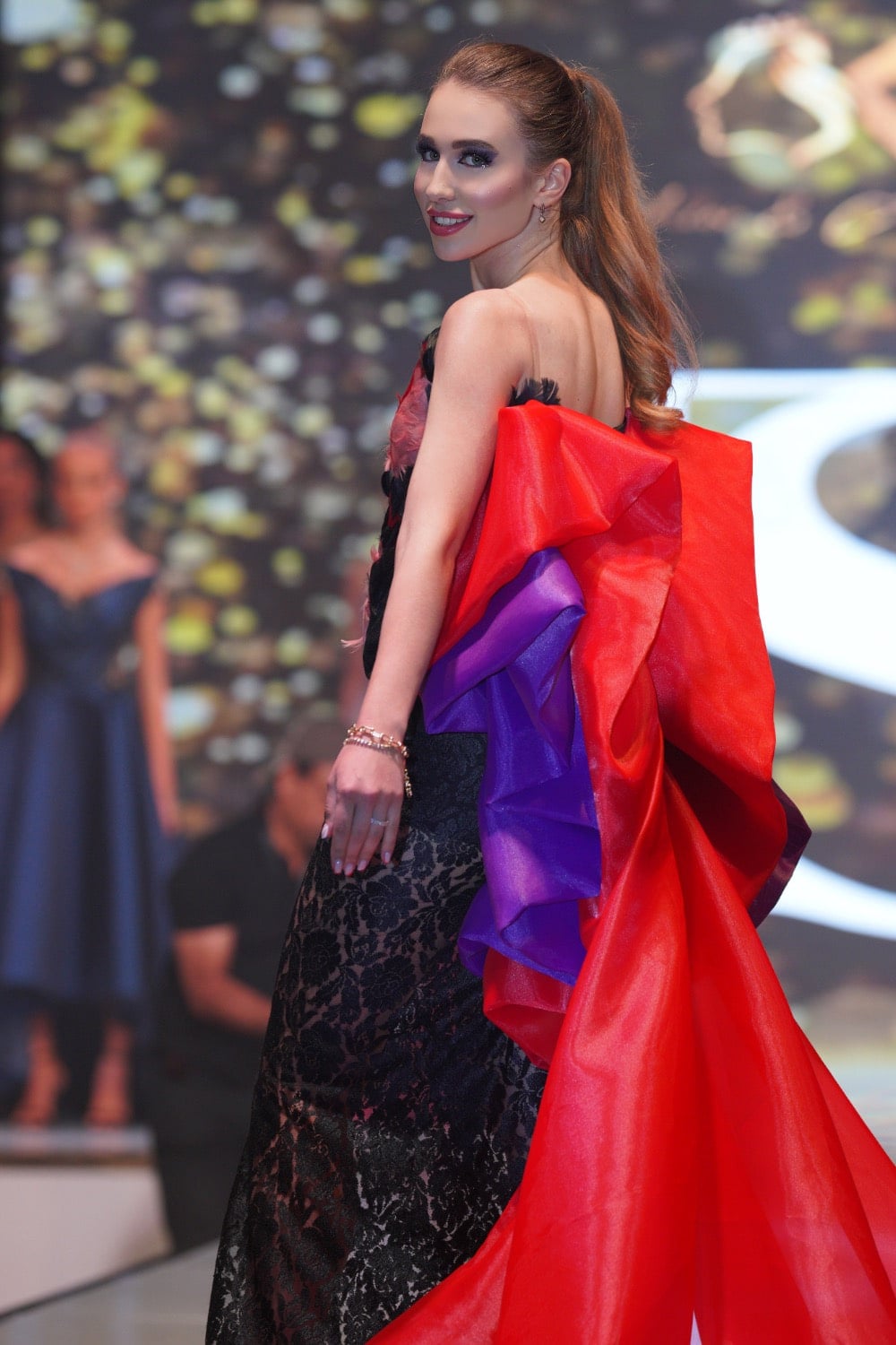 Vyacheslavivna turning on the runway in a vivid red gown